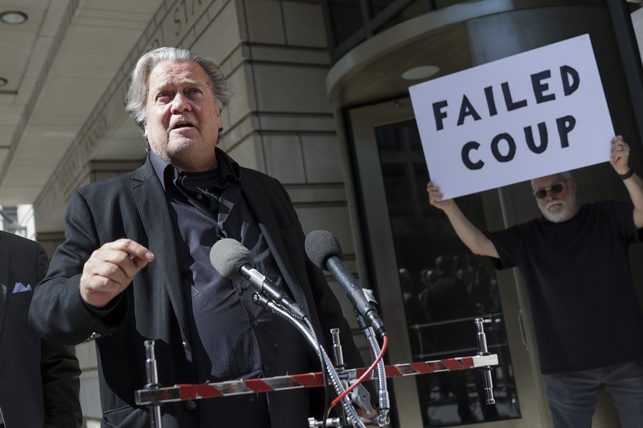 WASHINGTON, DC - JUNE 15: Steve Bannon, advisor to former President Donald Trump, speaks to the media as a protester stands behind him, outside of the E. Barrett Prettyman U.S. Courthouse on June 15, 2022 in Washington, DC. Bannon is appearing before a federal judge in connection with his indictment for contempt of Congress for failing to respond to a subpoena from the House Judiciary Committee on January 6. (Photo by Kevin Dietsch/Getty Images)