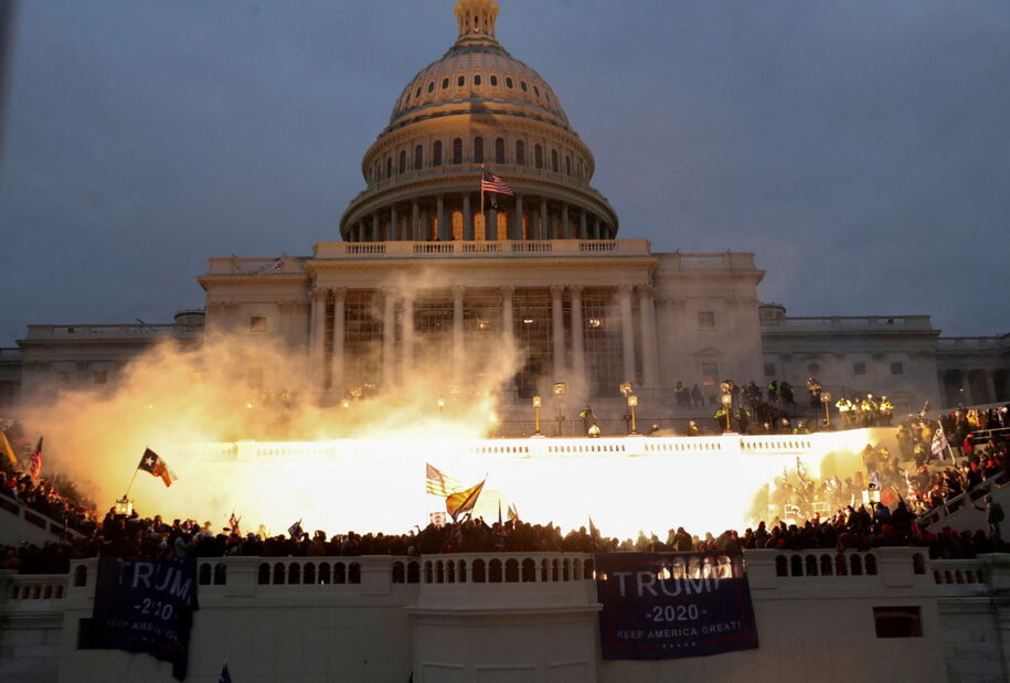FILE PHOTO: An explosion caused by a police munition is seen while supporters of U.S. President Donald Trump gather in front of the U.S. Capitol Building in Washington, U.S., January 6, 2021.  Reuters photographer Leah Millis: 'Thousands of supporters of then-President Donald Trump, a Republican, stormed the U.S. Capitol on Jan. 6 in a failed attempt to overturn the recent election and prevent Joe Biden, a Democrat, from becoming the next president. It was the worst attack on the seat of the U.S. government since the War of 1812. I arrived at the west side of the U.S. Capitol before the Trump supporters overwhelmed police lines, and I documented the chaos that ensued for the next seven hours. At one point I heard the crowd chanting 'heave-ho' and thought they must be breaking in through the doors. I didn't want to risk getting crushed or injured by the massive crowd, which was hostile toward members of the media and had already assaulted several of my colleagues that day. I chose to risk climbing some scaffolding that had been erected for the upcoming inauguration to give me a better view. The Capitol had already been breached via different entrances, but the fight for this entrance went on for hours. Capitol and D.C. Metropolitan police officers engaged in hand-to-hand combat with the mob of Trump supporters and in the process multiple officers were severely injured. Four people would die that day and a police officer attacked by protesters died the next day. Four officers later took their own lives. Eventually, law enforcement was able to successfully push the crowd back. At 5:04 p.m. to disperse the remaining protesters, they used a flash-bang grenade, which released a blinding light that illuminated the U.S. Capitol building. To me, the explosion of the grenade captured the violence and shock of the day: American citizens attacking and breaching their own country's Capitol building. The haunting sight of the American flag flying above the entire scene, casting a