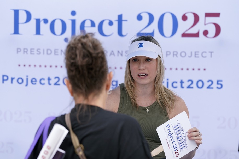 Kristen Eichamer, right, talks to a fairgoer at the Project 2025 tent at the Iowa State Fair, Aug. 14, 2023, in Des Moines, Iowa. With more than a year to go before the 2024 election, a constellation of conservative organizations is preparing for a possible second White House term for Donald Trump. The Project 2025 effort is being led by the Heritage Foundation think tank. (AP Photo/Charlie Neibergall)