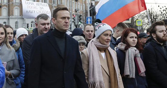 In this photo taken on Saturday, March 29, 2020, Russian opposition activist Alexei Navalny, center left, and his wife Yulia, take part in a march in memory of opposition leader Boris Nemtsov in Moscow, Russia. Russian opposition leader Alexei Navalny said Tuesday the government has frozen all of his bank accounts, as well as the accounts of his wife, his two children and his elderly parents. (AP Photo/Pavel Golovkin)