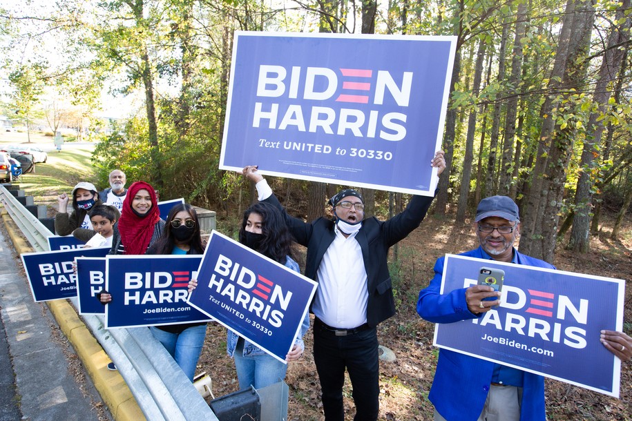 NORCROSS, GA - NOVEMBER 03: Gwinnett county voters including Menar Hague (C) wave Biden-Harris campaign signs at the entrance to Lucky Shoals Park polling station on November 3, 2020 in Norcross, Georgia.   After a record-breaking early voting turnout, Americans head to the polls on the last day to cast their vote for incumbent U.S. President Donald Trump or Democratic nominee Joe Biden in the 2020 presidential election. (Photo by Jessica McGowan/Getty Images)