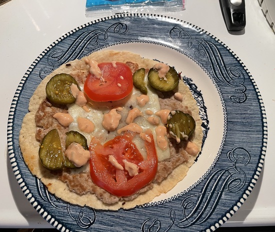 cooked smash burger taco with pickles, tomato slices and burger sauce before folding