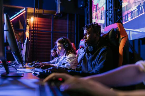 Diverse people in gaming chairs playing video games. Free download with attribution.