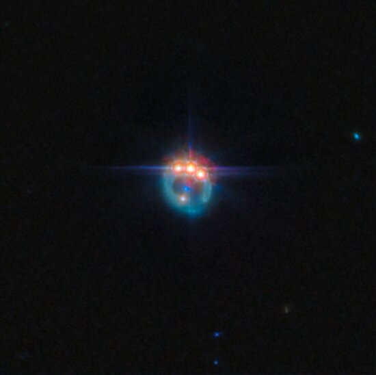 This new ESA/Webb Picture of the Month features the gravitational lensing of the quasar known as RX J1131-1231, located roughly 6 billion light-years from Earth in the constellation Crater. It is considered one of the best lensed quasars discovered to date, as the foreground galaxy smears the image of the background quasar into a bright arc and creates four images of the object. Gravitational lensing, first predicted by Einstein, offers a rare opportunity to study regions close to the black hole in distant quasars, by acting as a natural telescope and magnifying the light from these sources. All matter in the Universe warps the space around itself, with larger masses producing a more pronounced effect. Around very massive objects, such as galaxies, light that passes close by follows this warped space, appearing to bend away from its original path by a clearly visible amount. One of the consequential effects of gravitational lensing is that it can magnify distant astronomical objects, letting astronomers study objects that would otherwise be too faint or far away. Measurements of the X-ray emission from quasars can provide an indication of how fast the central black hole is spinning, which can provide researchers important clues about how black holes grow over time. For example, if a black hole grows primarily from collisions and mergers between galaxies, it should accumulate material in a stable disc, and the steady supply of new material from the disc should lead to a rapidly spinning black hole. On the other hand, if the black hole grew through many small accretion episodes, it would accumulate material from random directions. Observations have indicated that the black hole in this particular quasar is spinning at over half the speed of light, which suggests that this black hole has grown via mergers, rather than pulling material in from different directions. This image was captured with Webb’s MIRI (Mid-Infrared Instrument) as part of an observation programme t