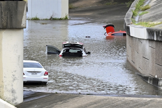 Buffalo Bayou floods stranding vehicles near Downtown Houston after Beryl came ashore in Texas as a hurricane and dumped heavy rains downtown. (AP Photo/Maria Lysaker)