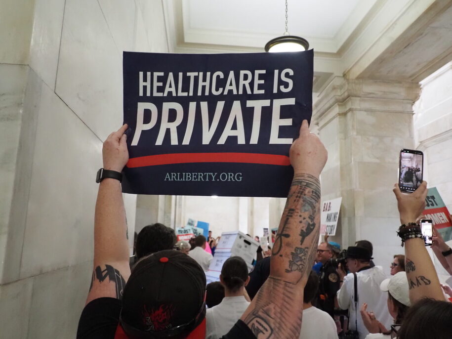  A supporter of the Arkansas Abortion Amendment holds up a sign in an Arkansas Capitol hallway while petitions to put the amendment on the November ballot are delivered in boxes to the Secretary of State on Friday, July 5, 2024. (Tess Vrbin/Arkansas Advocate)