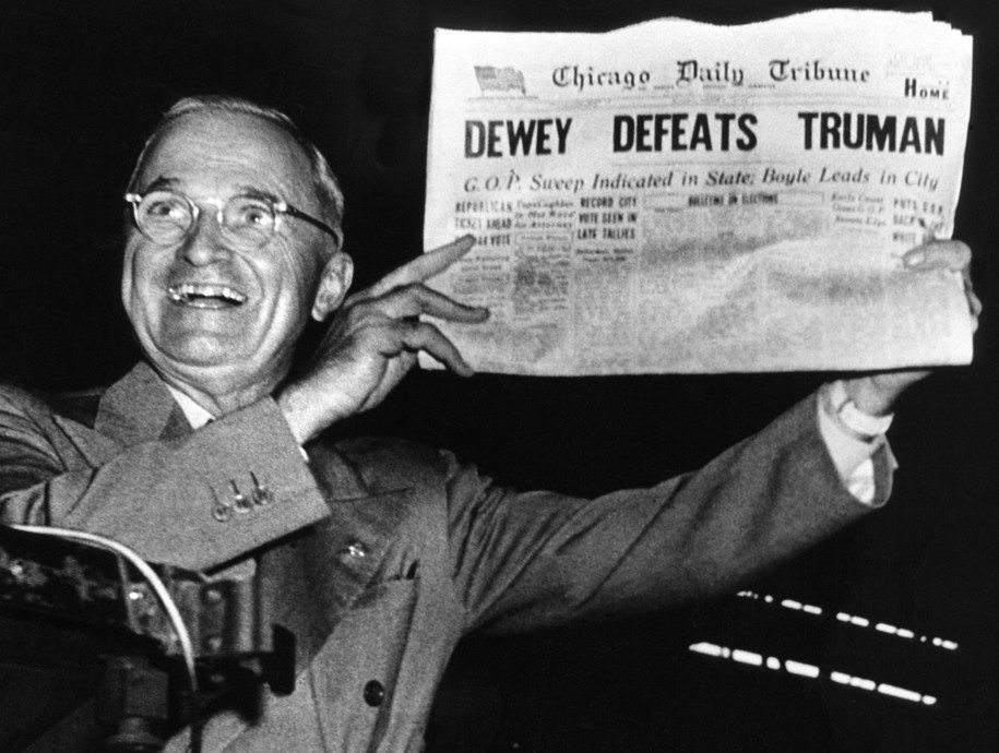 Victorious presidential candidate Pres. Harry Truman jubilantly displaying erroneous CHICAGO DAILY TRIBUNE w. headline DEWEY DEFEATS TRUMAN which overconfident Republican editors had rushed to print on election night, standing on his campaign train platfo