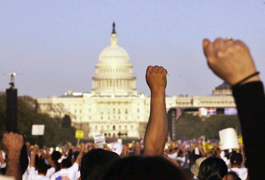 Washington, UNITED STATES:  Immigration protestors raise theis fists during an immigration rally on the National Mall before the US Capitol 10 April 2006 in Washington, DC. The demonstrators are demanding amnesty for an estimated 11.5 million illegal immigrants in the US. AFP PHOTO/Mandel NGAN  (Photo credit should read MANDEL NGAN/AFP/Getty Images)