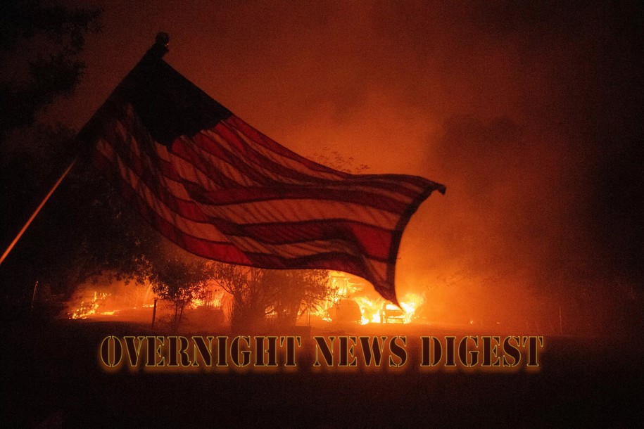 An American flag blows in the wind in front of a burning home in Vacaville, California during the LNU Lightning Complex fire on August 19, 2020.